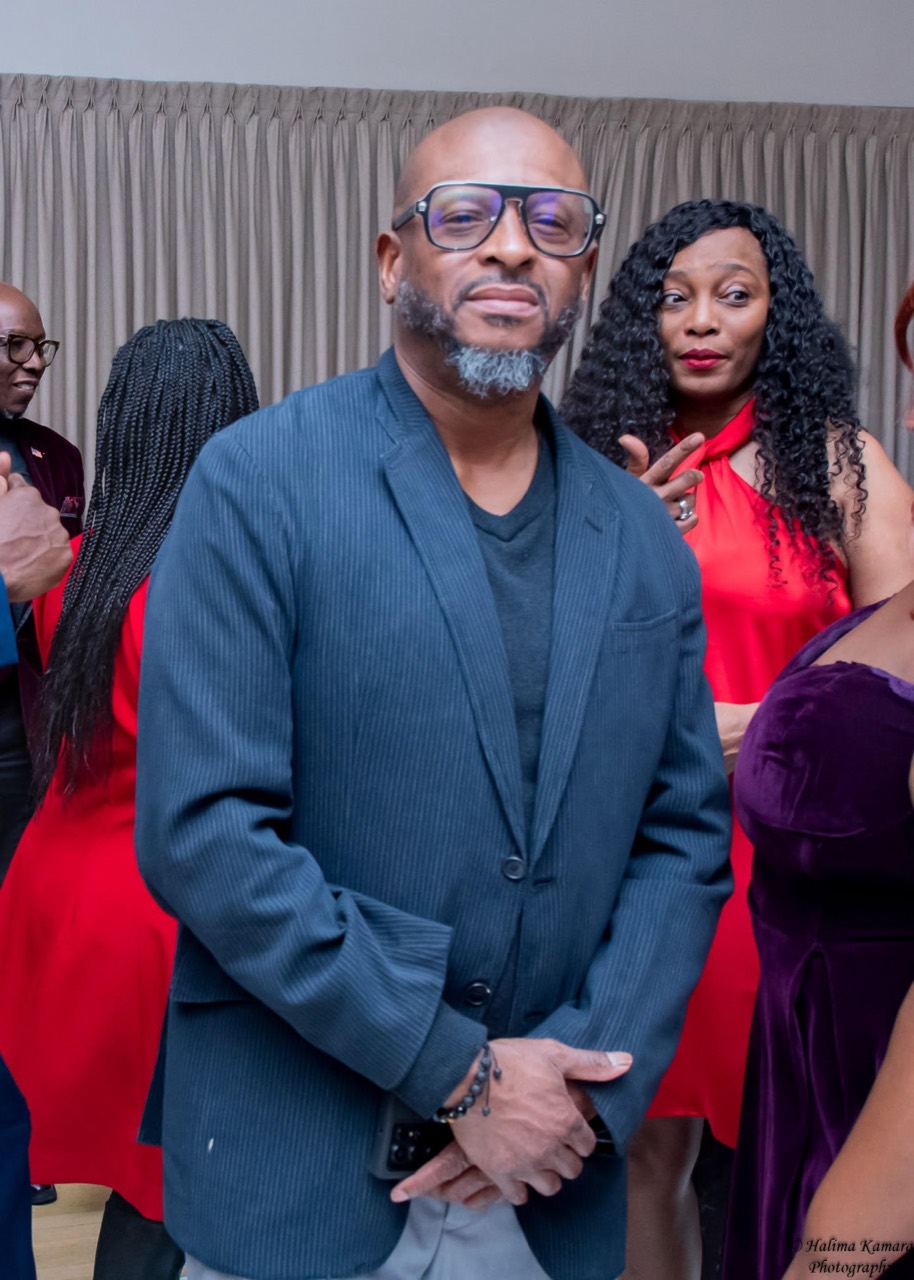 DJ VIBzzz at a celebration, wearing glasses and a blue jacket