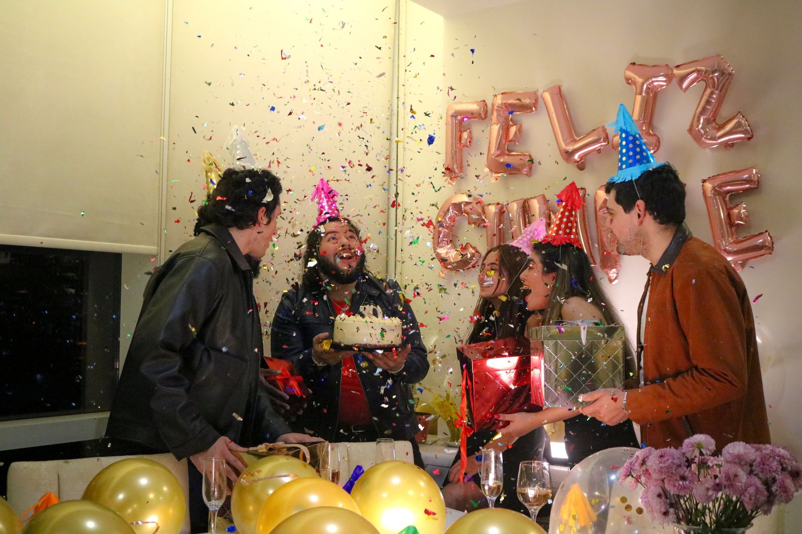 Friends celebrating a birthday together with cake and festive decorations