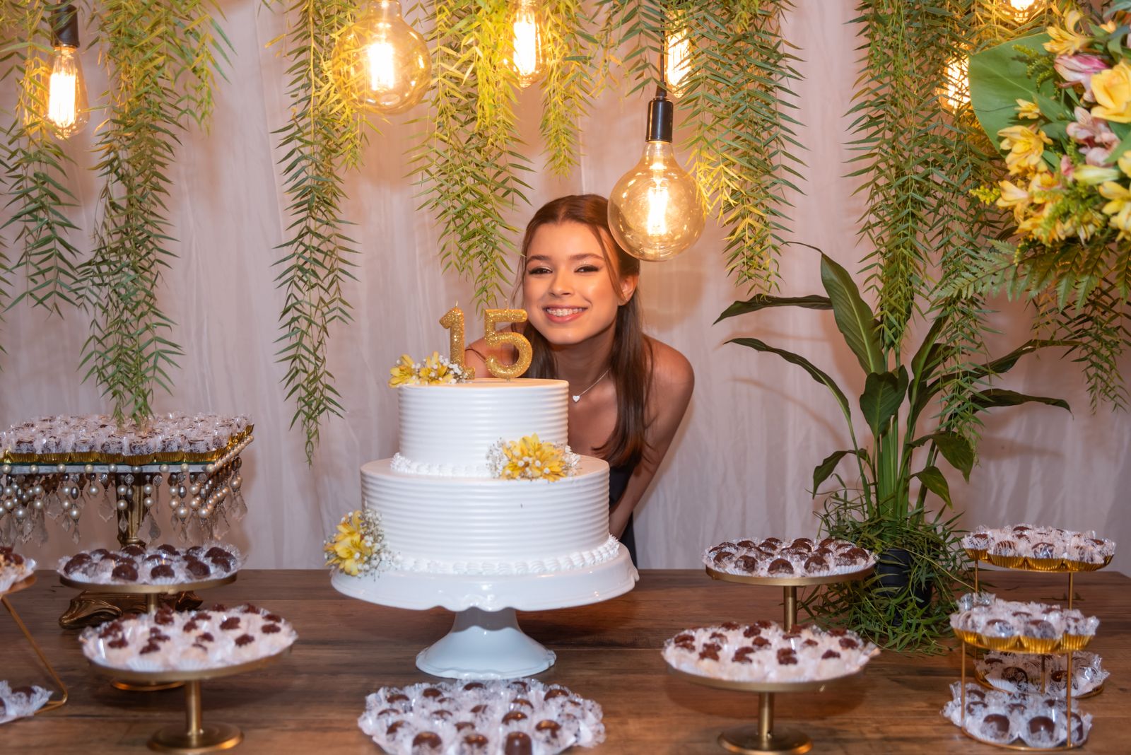 Guest of honor celebrating her quinceañera with cake and floral decorations